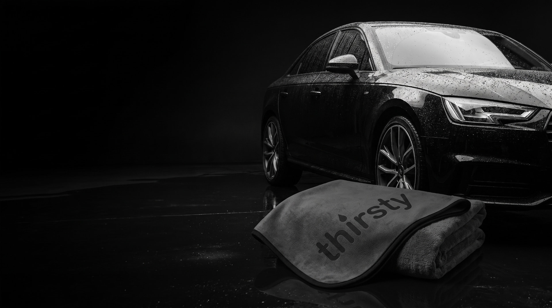 Charcoal car drying towels beside a freshly washed car